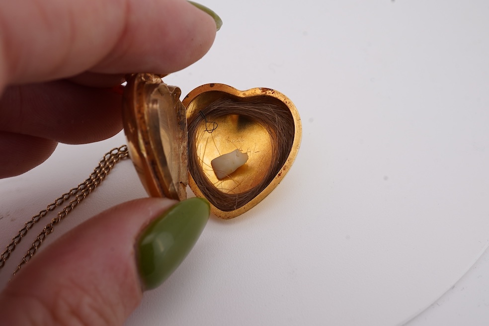 A modern embossed 9ct gold heart shaped locket, 21mm, on a similar 9ct gold rope twist chain, 46cm, together with one other yellow metal heart shaped locket, on a yellow metal chain, gross weight 14.5 grams. Condition -